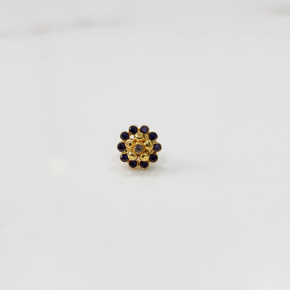 Front view of gold floral ring with purple gemstone petals
