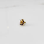 Gold floral ring with purple gemstone petals and textured gold center