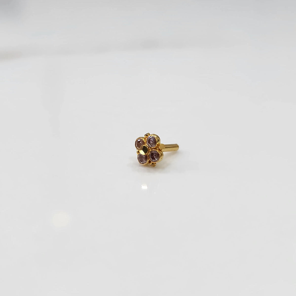 Gold floral nose pin with purple stones, product shot