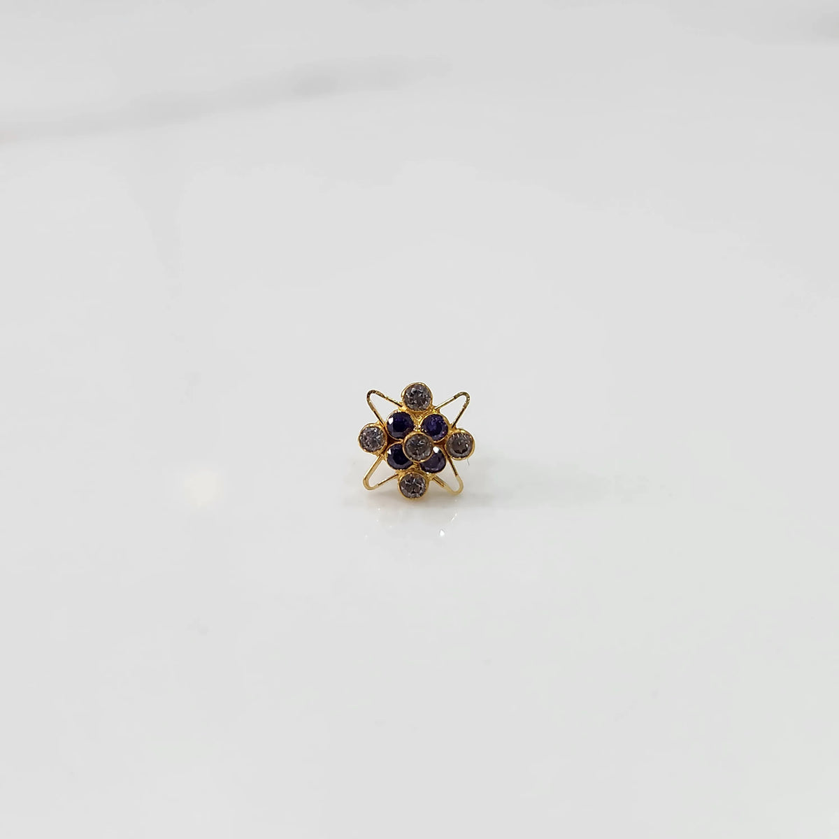 Side view of gold statement ring with purple gemstones in floral starburst setting