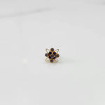 Side view of gold statement ring with purple gemstones in floral starburst setting