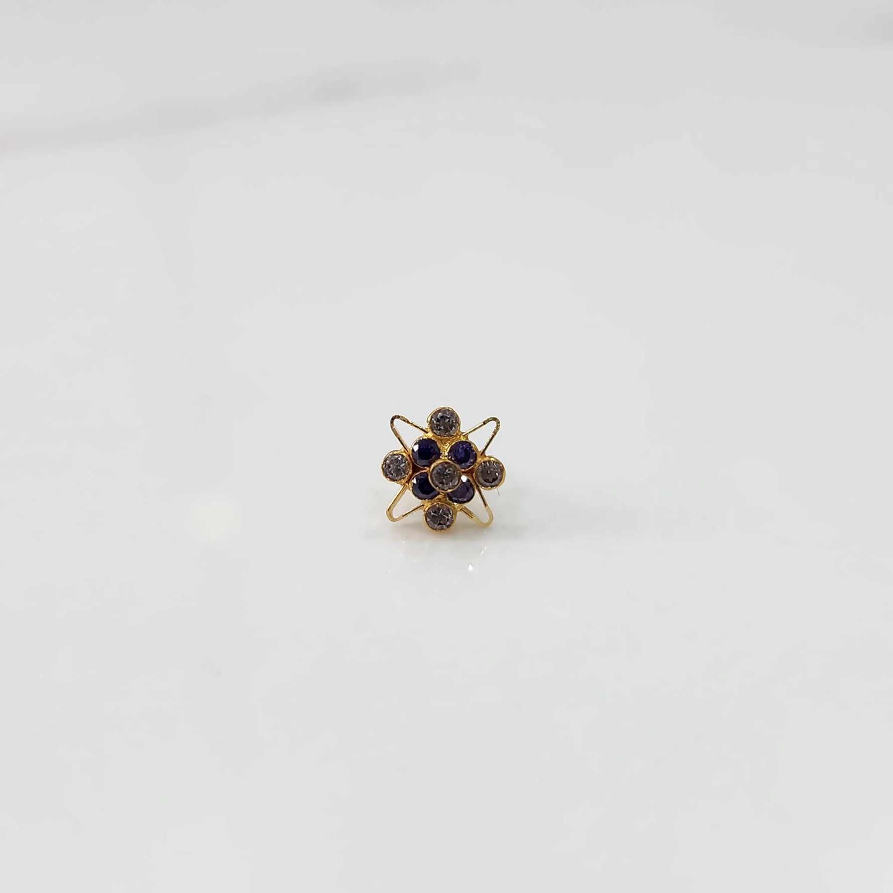 Side view of gold statement ring with purple gemstones in floral starburst setting