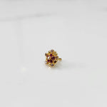 Gold statement ring with red and brown gemstones in textured floral cluster design
