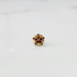 Front view of gold statement ring with red and brown gemstones in textured cluster design