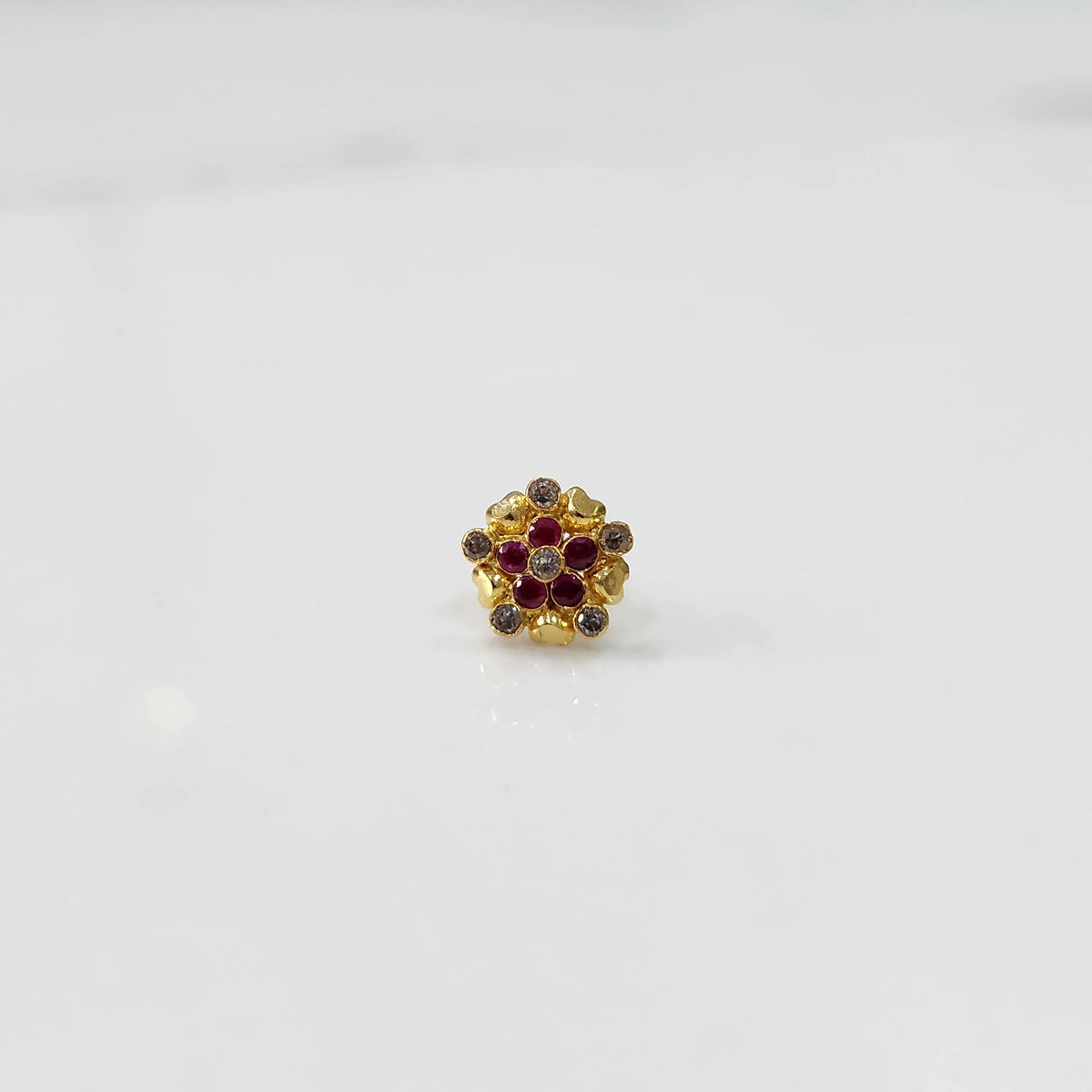 Front view of gold statement ring with red and brown gemstones in textured cluster design