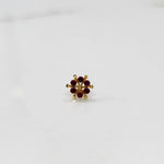 Front view of gold statement ring with red cabochon gemstones in scattered cluster design