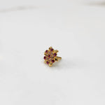 Gold statement ring with red and clear gemstones in leaf-patterned cluster design
