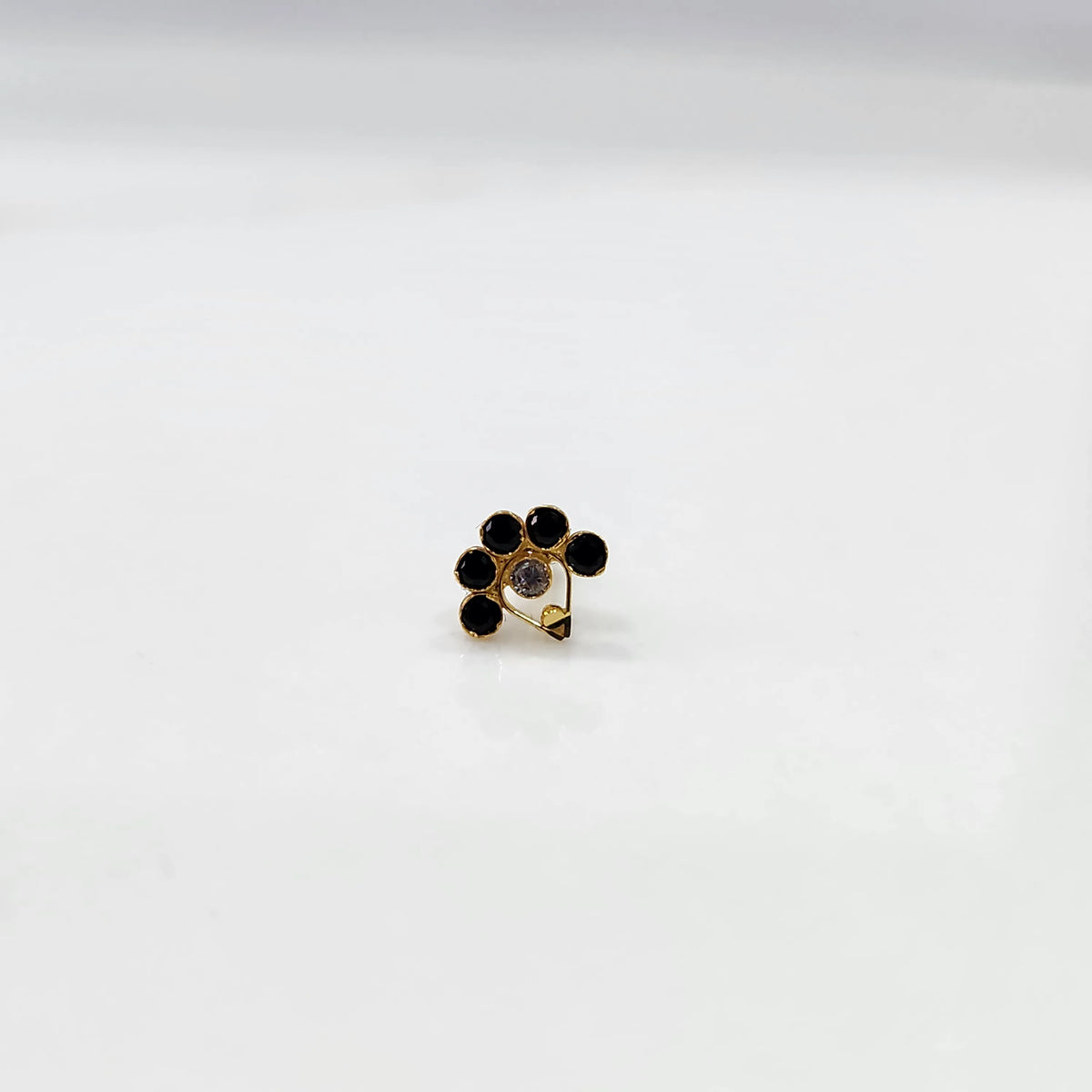 Gold ring with black and clear flower cluster and dangling drop stone
