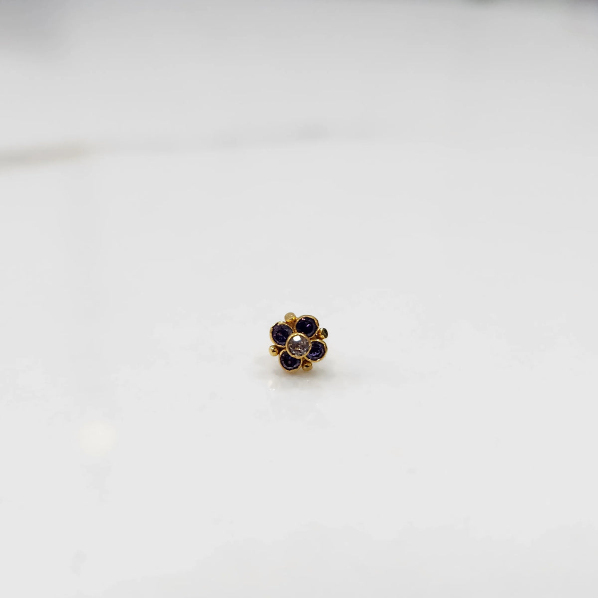 Gold ring with blue sapphire round floral design, front view