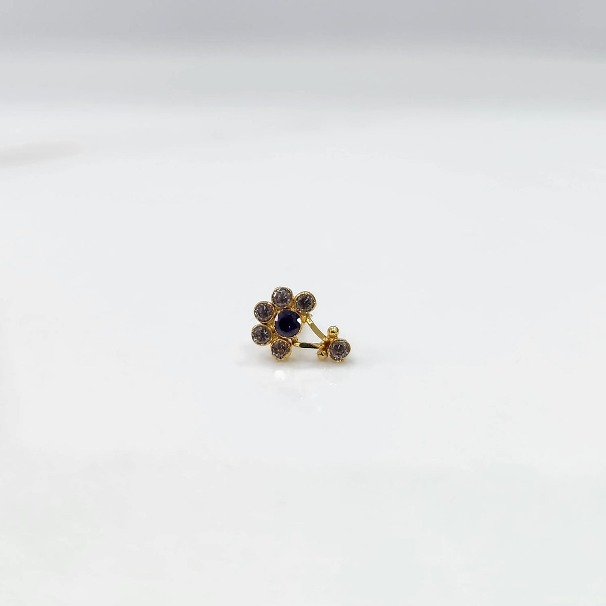 Gold ring with clear and blue flower cluster and dangling drop stone