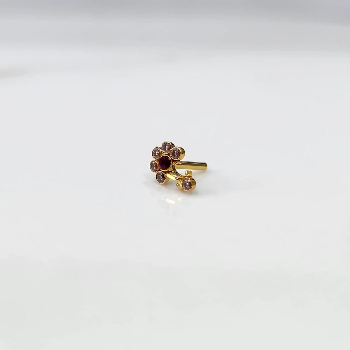 Gold ring with clear and red flower cluster and dangling drop stone