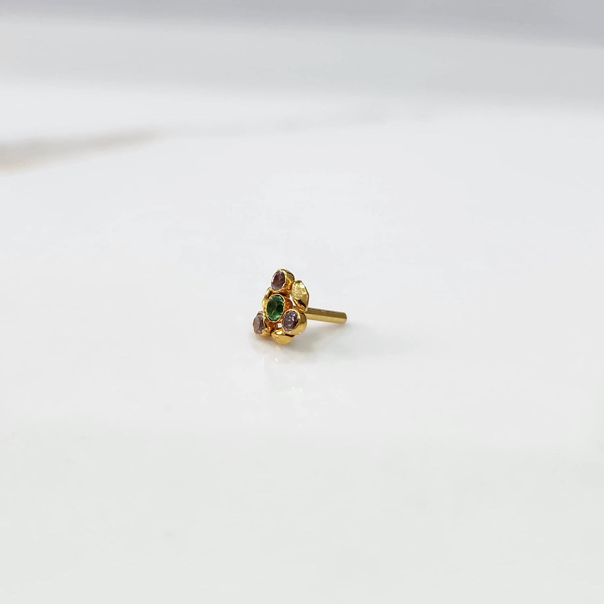 Front view of gold ring featuring green gemstone cluster with leaf accents