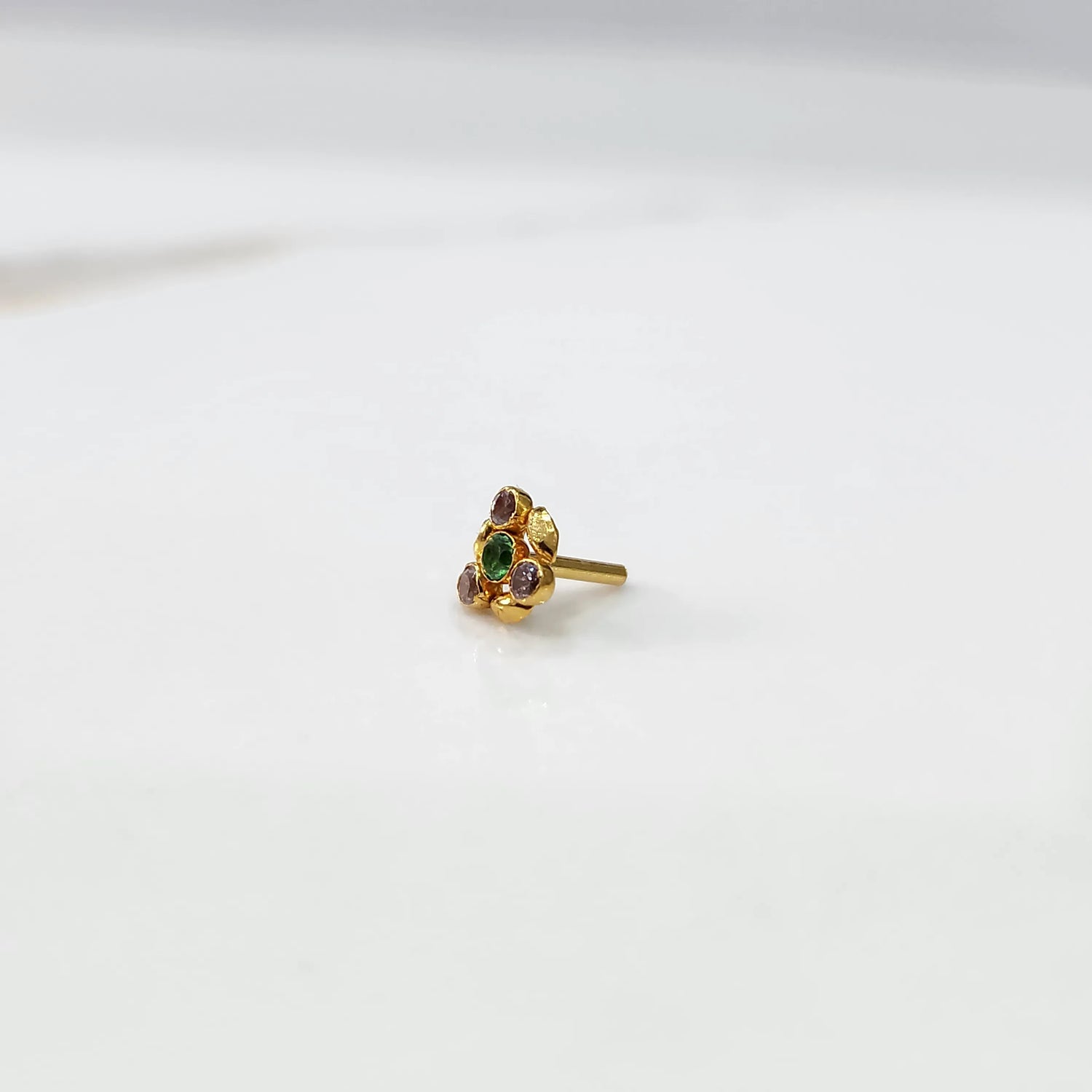 Front view of gold ring featuring green gemstone cluster with leaf accents