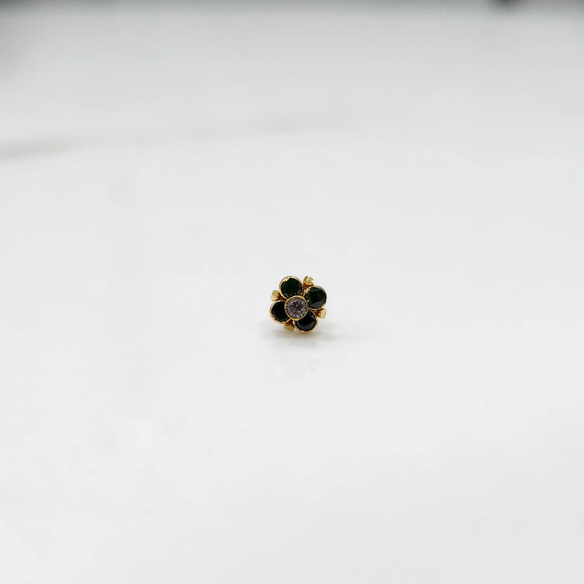 Gold ring with green emerald round floral design, front view