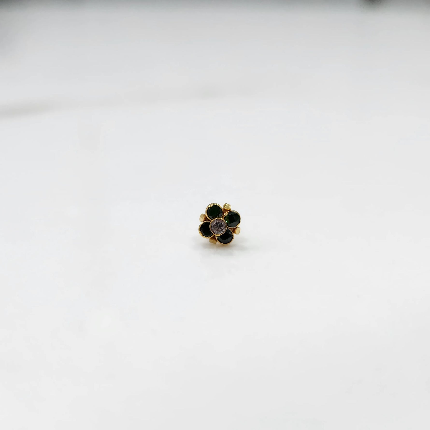 Gold ring with green emerald round floral design, front view