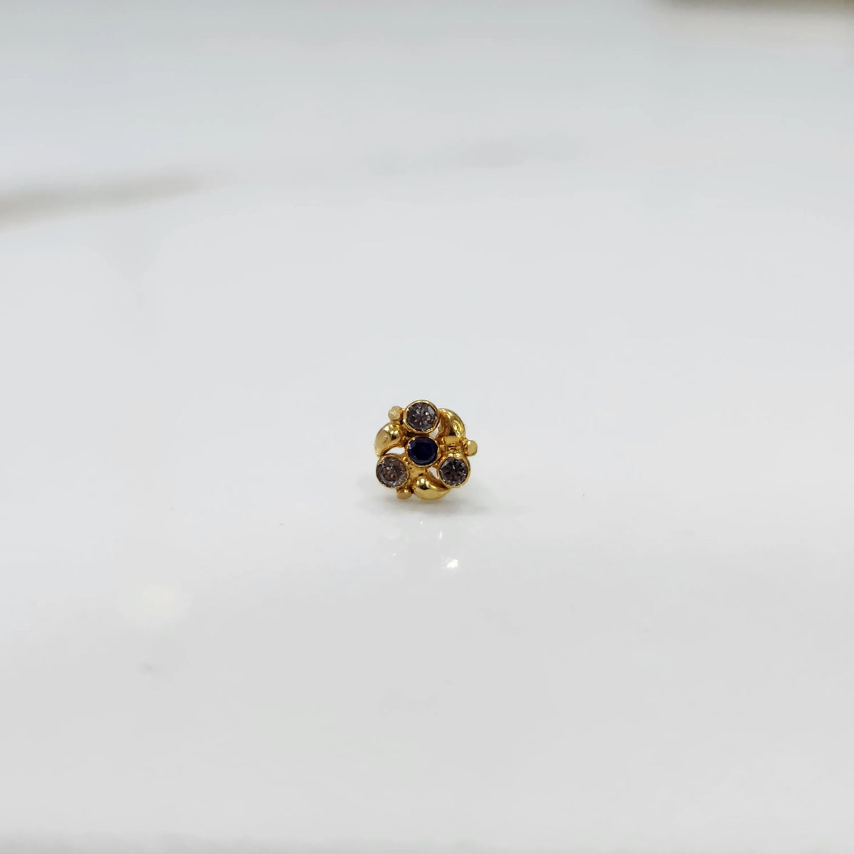 Front view of gold ring featuring blue and brown gemstone cluster in round floral pattern