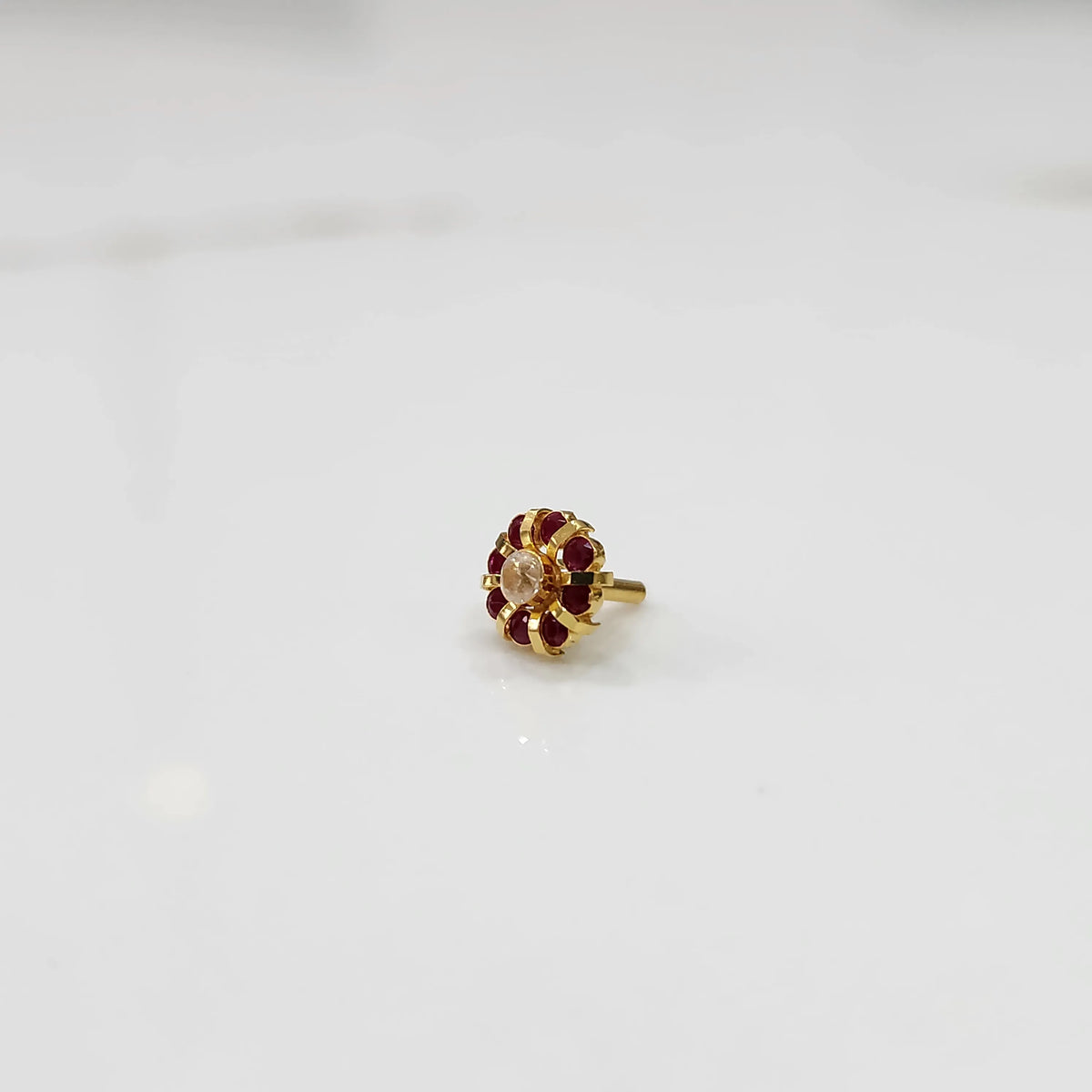 Gold ring with sculpted petal design and champagne center with ruby-red stones