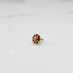Gold ring with sculpted petal design and champagne center with ruby-red stones