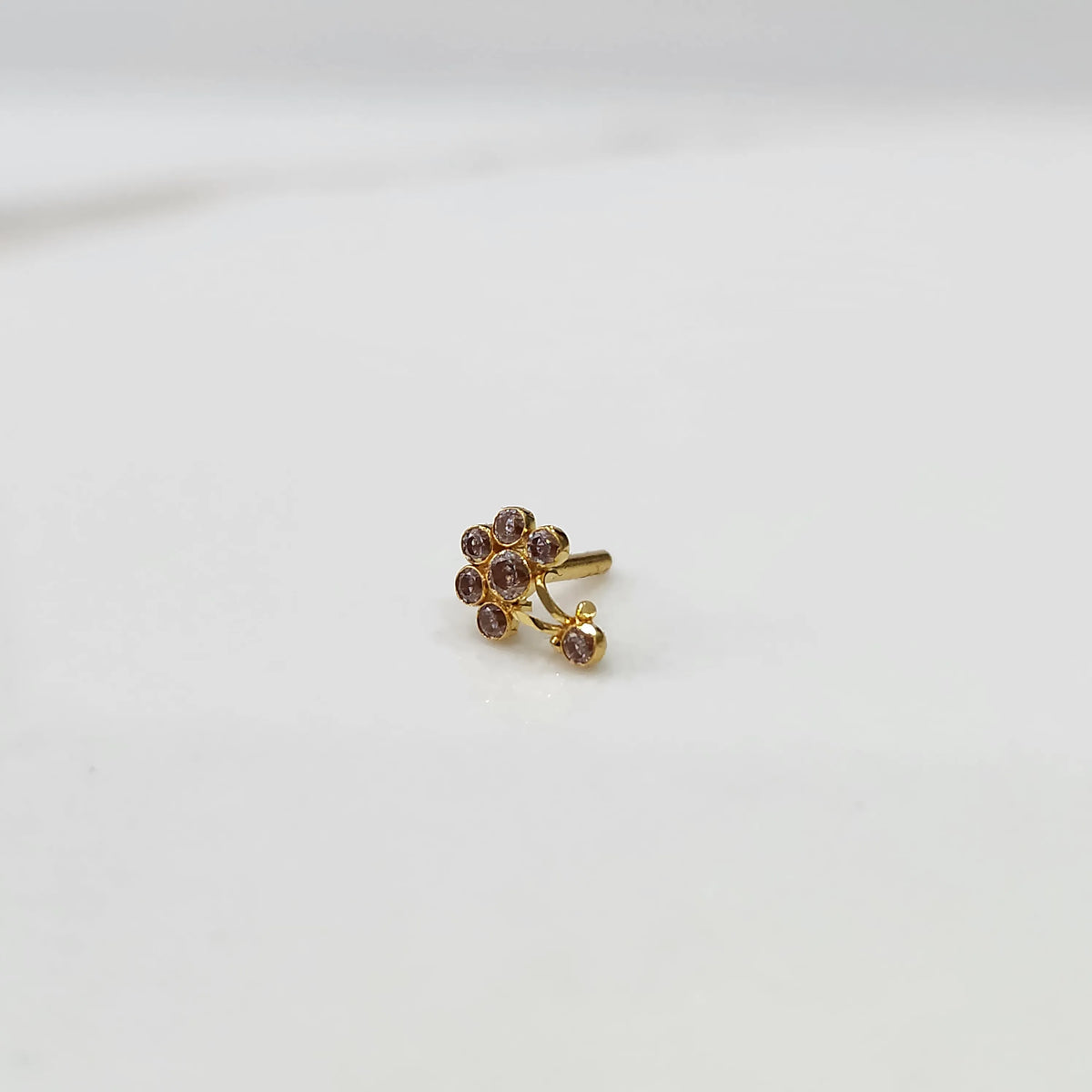 Gold ring with purple flower cluster and dangling drop stone