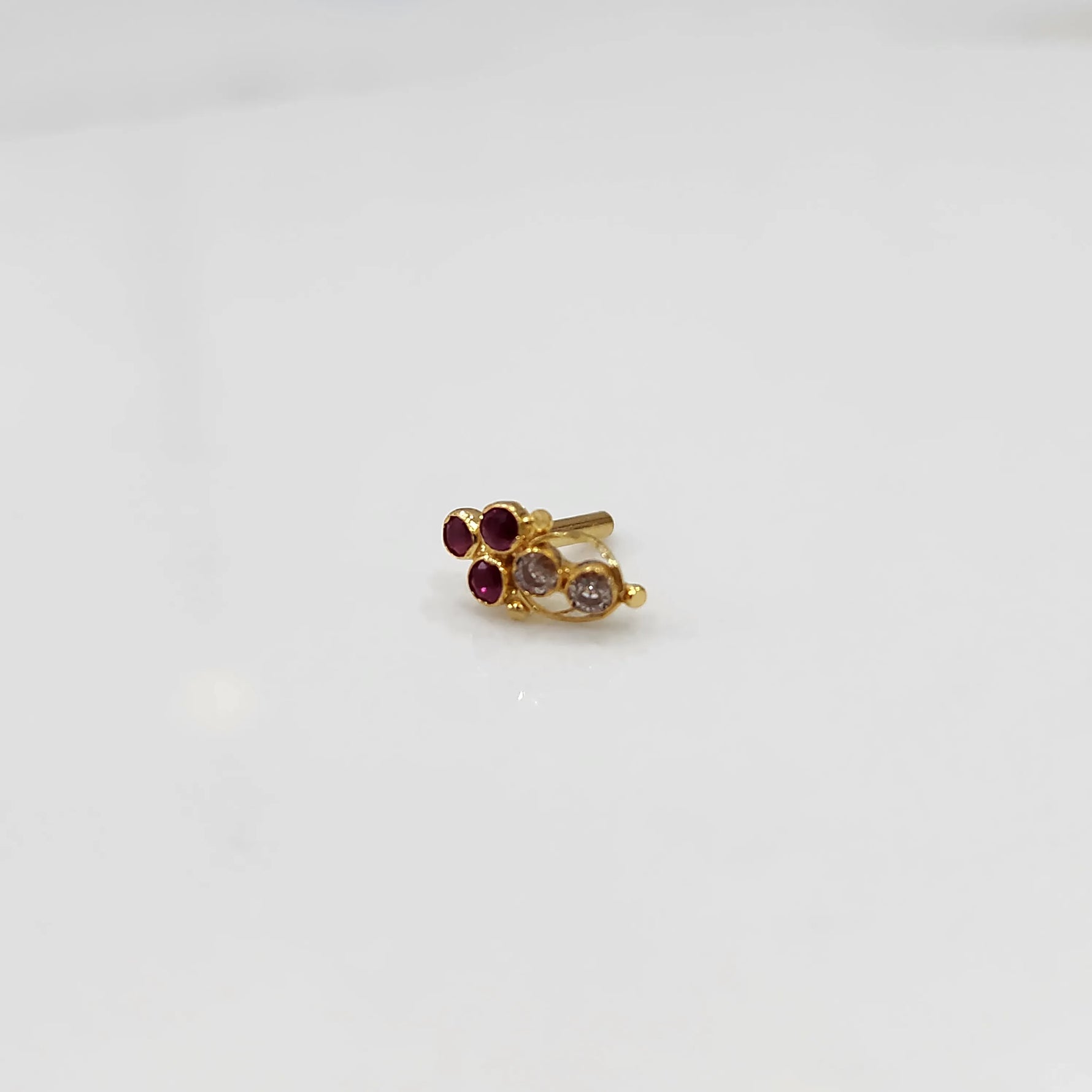 Gold ring with red and clear round gemstone cluster design