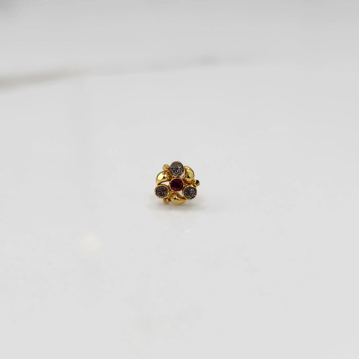 Gold ring with red and smoky gemstone round floral design, front view