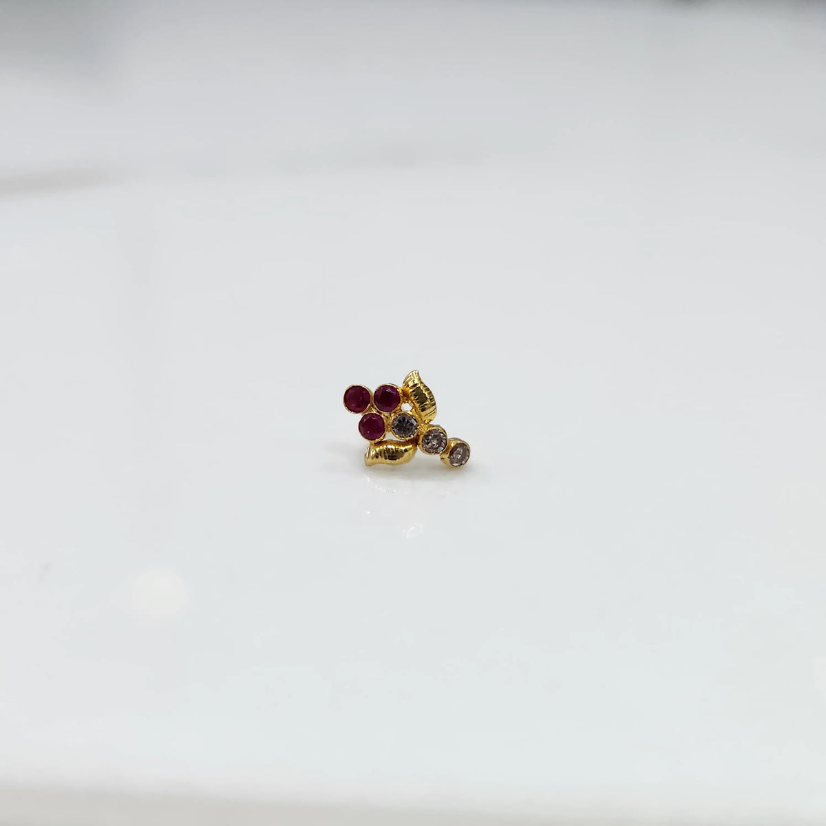 Gold ring with red ruby leaf-charm cluster design, side view