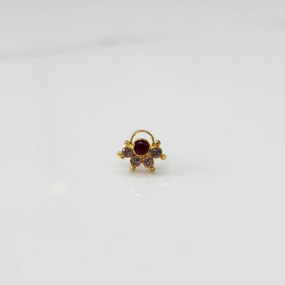 Close-up of gold multicolor cluster ring with red and clear stones