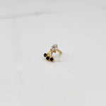 Side view of gold ring with square clear stone and black gemstone drop design