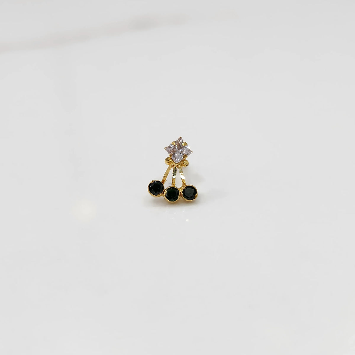 Gold ring with square clear stone and black gemstone drop design