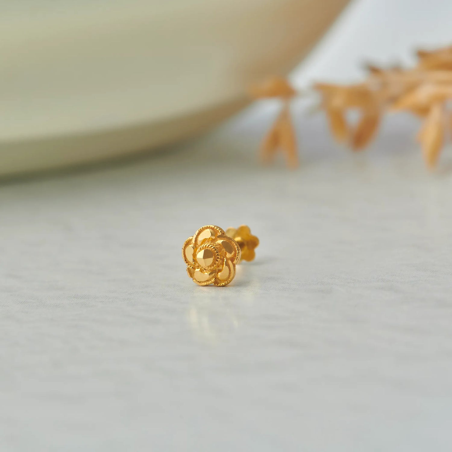 Gold rose-shaped stud earring with scalloped petal edges