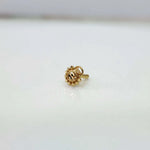 Side view of a round gold nose pin with beaded border and straight post fitting