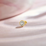 Gold nose stud featuring a round bezel-set gemstone cluster design