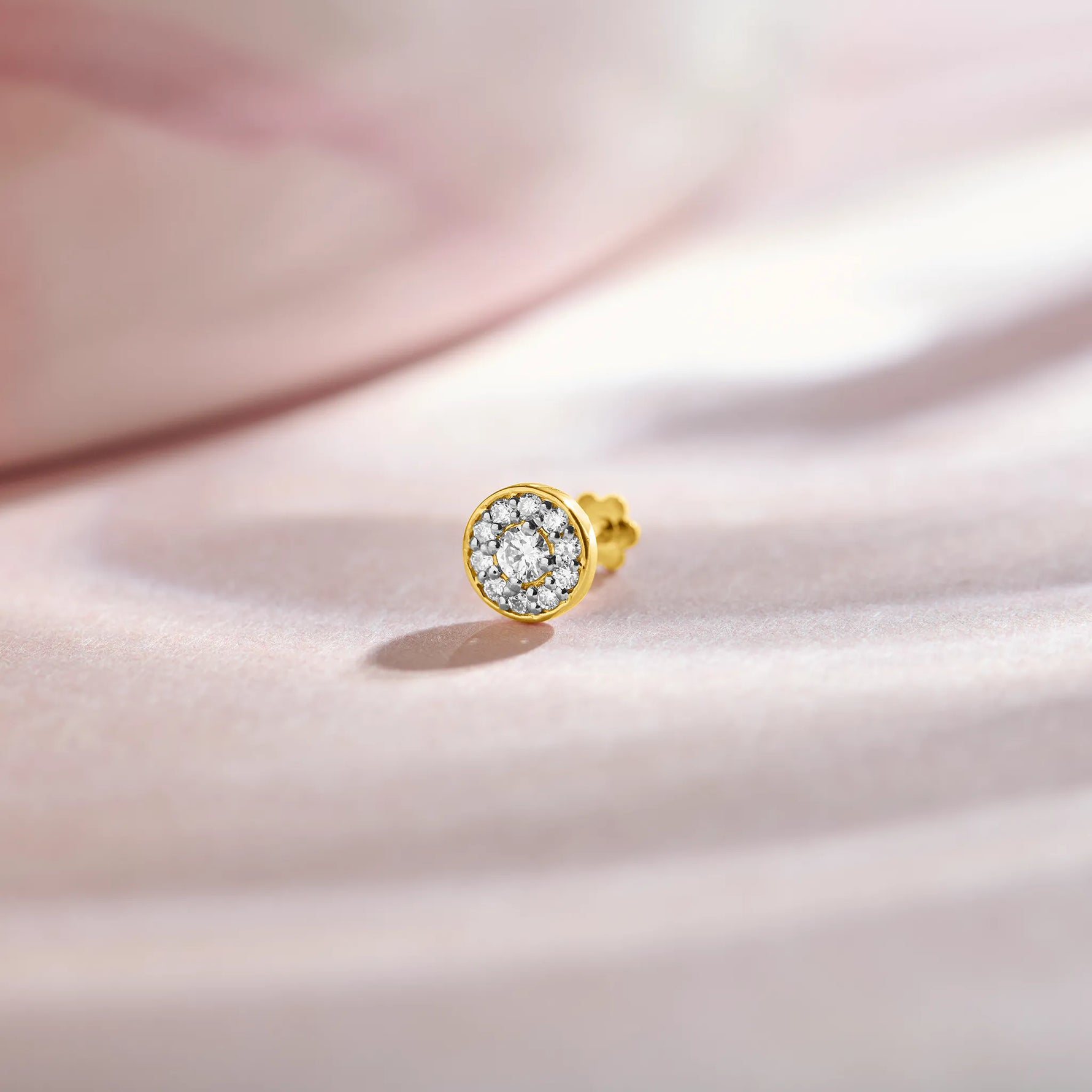 Gold nose stud featuring a round bezel-set gemstone cluster design