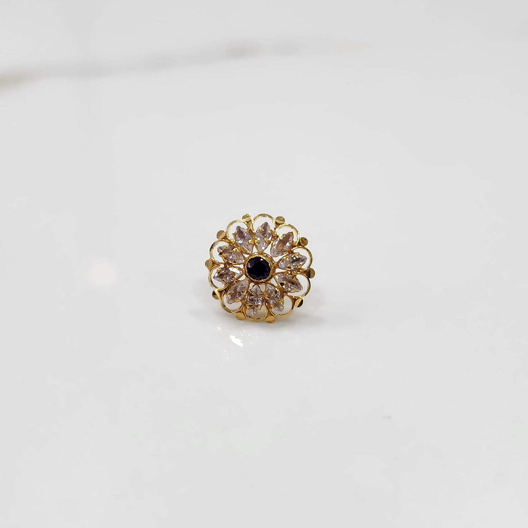 Gold round ring with clear and black gemstones, front view