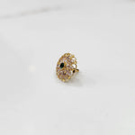 Gold round ring with clear and green gemstones, side view