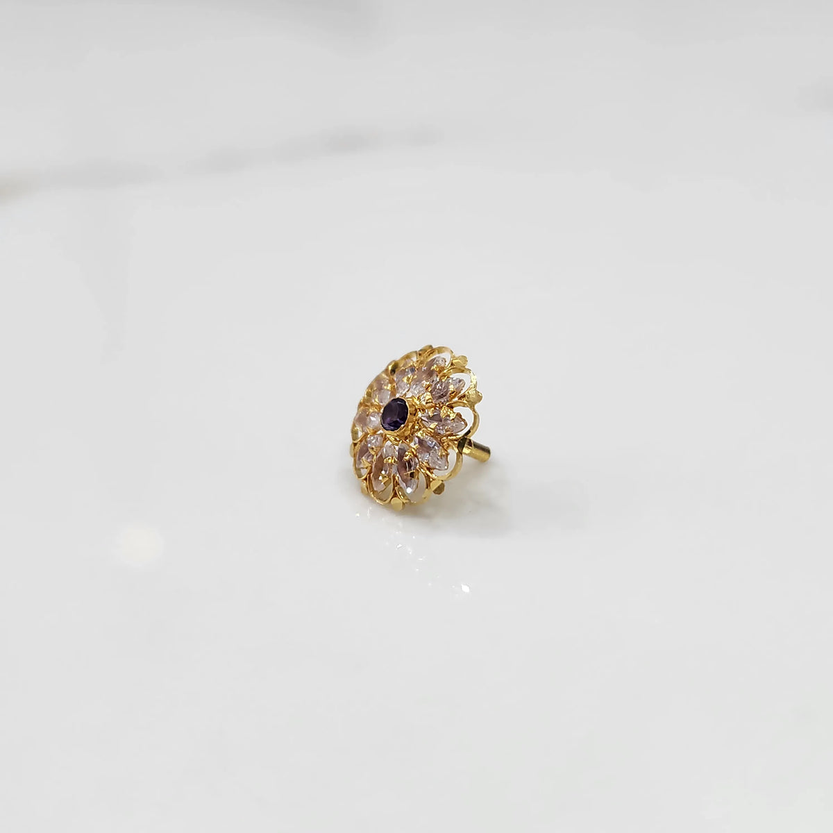 Gold round ring with clear and purple gemstones, front view