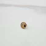 Round gold nose pin with honeycomb pattern and screw-back on a white background
