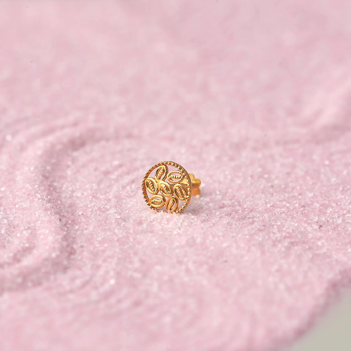 Gold round stud earring with textured leaf pattern
