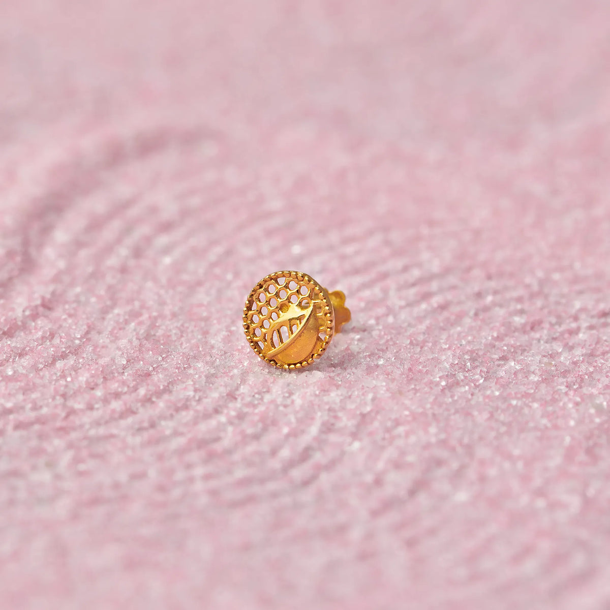Gold round stud earring with textured leaf pattern