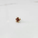 Gold statement ring with ruby red and clear gemstones in floral starburst design