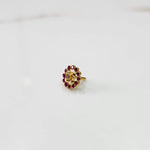 Gold floral nose pin with ruby-red stone halo, product shot