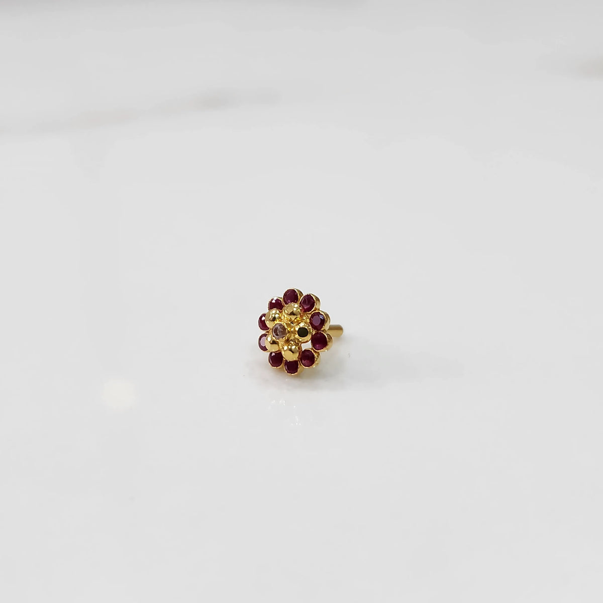 Gold floral ring with ruby-red outer stones and champagne inner stones
