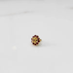Gold floral ring with ruby-red outer stones and champagne inner stones