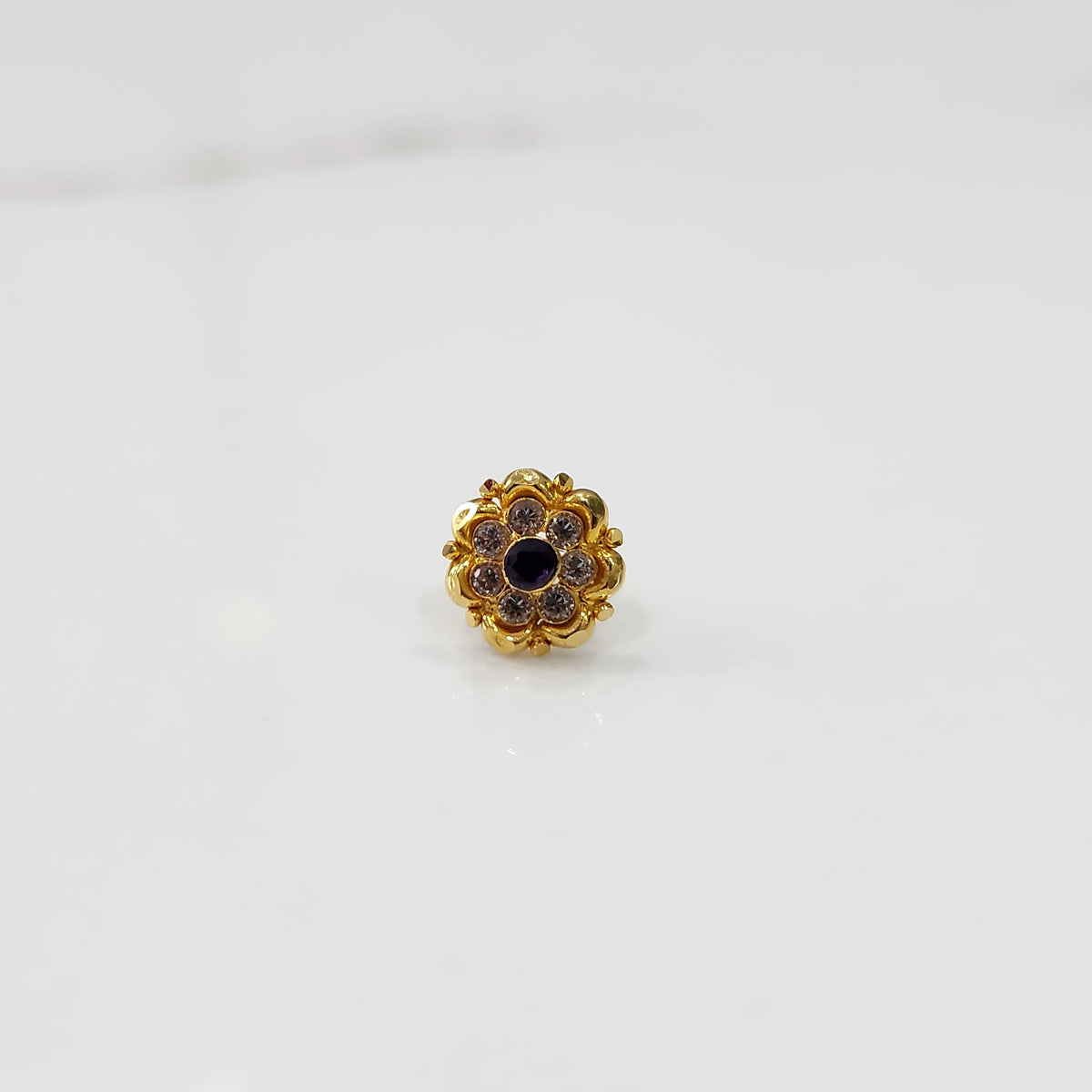 Angled view of gold floral ring with black center stone