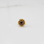 Angled view of gold floral ring with black center stone