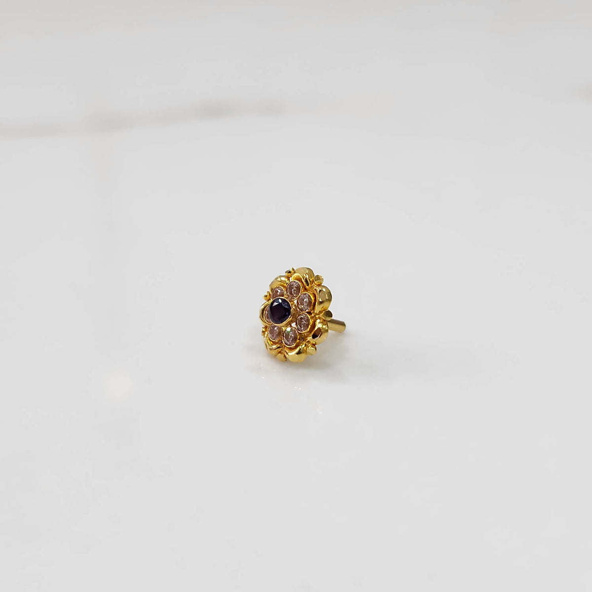 Traditional gold ring featuring a sapphire center with scalloped petal border