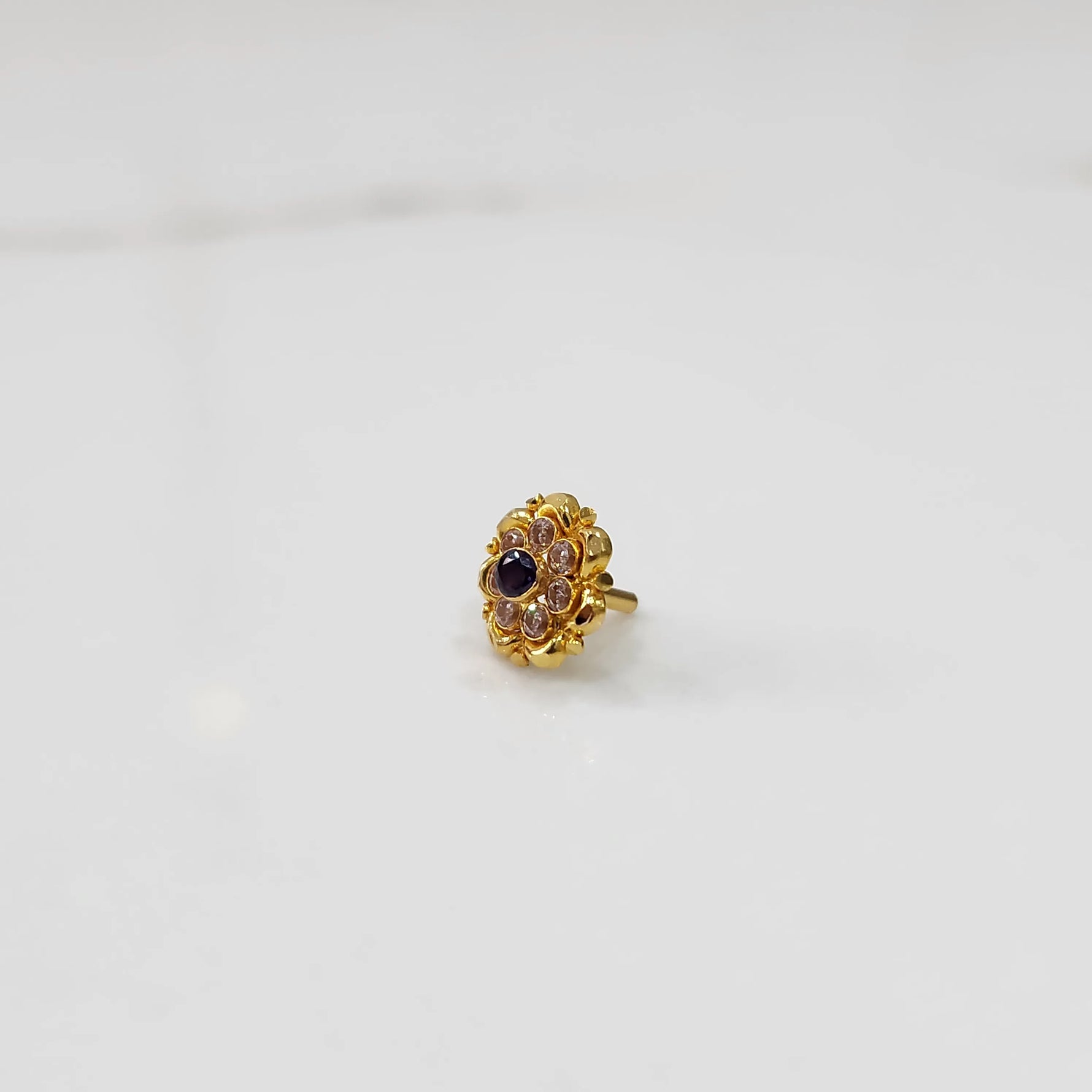Traditional gold ring featuring a sapphire center with scalloped petal border
