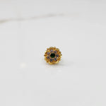 Top view of gold floral ring with green center stone