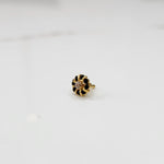 Gold ring with sculpted petal design and clear center with black stones