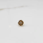 Top view of gold ring with clear center stone and purple petal stones